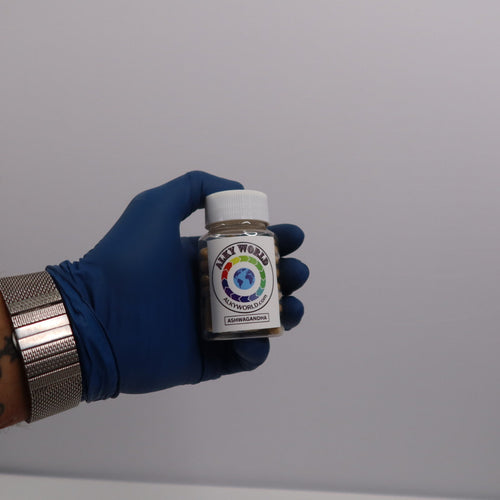 Hand wearing a blue glove holding a small bottle of Ashwagandha